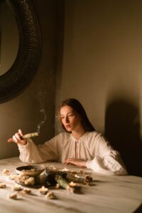 Woman in White Dress Holding a Smoking Weed