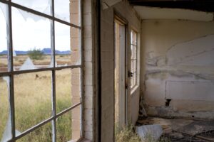A view of an abandoned house with a window and a door