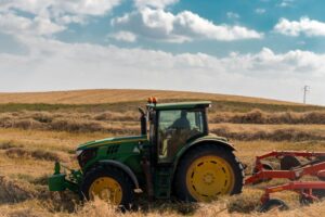 Green Tractor with Chisel Plow on Brown Hayfield