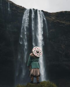 Person in Warrior Clothes Standing and Looking at Waterfall