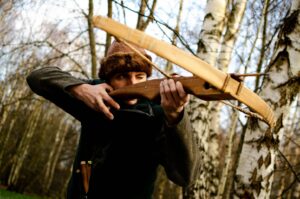 Man Using Crossbow in Forest