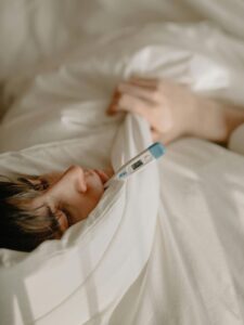 Woman in White Scrub Shirt Lying on Bed