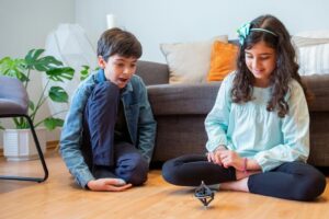 Kids Playing with the Gyroscope on the Wooden Floor